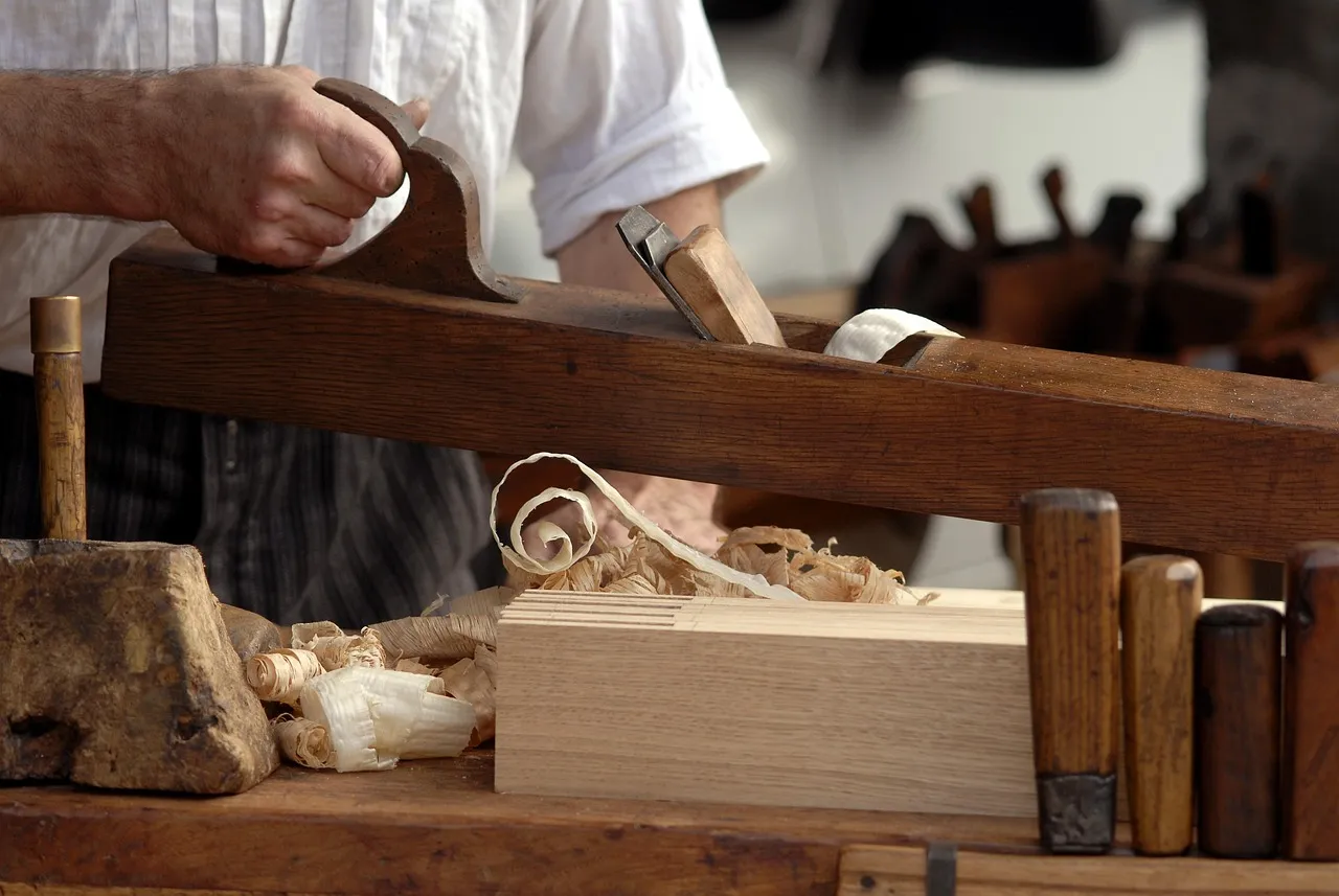 Tischler bearbeitet Holz in der Werkstatt